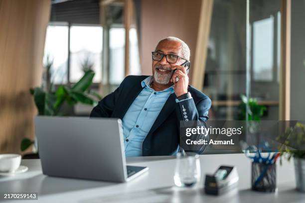 senior diverse executive engaging in conversation via smartphone - een dag uit het leven serie stockfoto's en -beelden