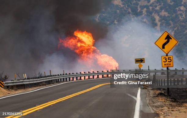 Erratic winds create small firestorms along the side of Highway 330 during the Line fire on September 8, 2024 in Highland, California.