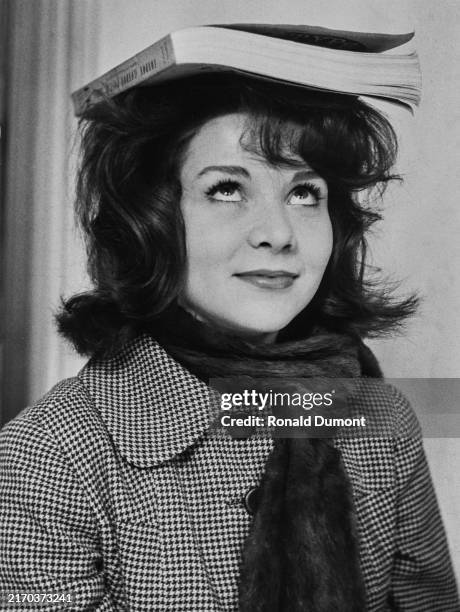 Actress Judy Huxtable balancing a book on her head, April 20th 1960.