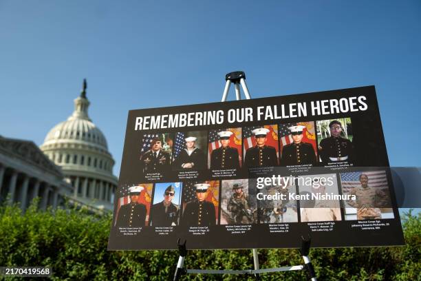 Sign displaying photos and names of the 13 service members killed in a terrorist attack at Abbey Gate outside Kabul's Hamid Karzai International...