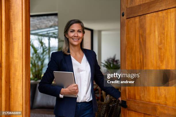 agente inmobiliario abriendo la puerta de una casa para una visita - agente inmobiliario fotografías e imágenes de stock