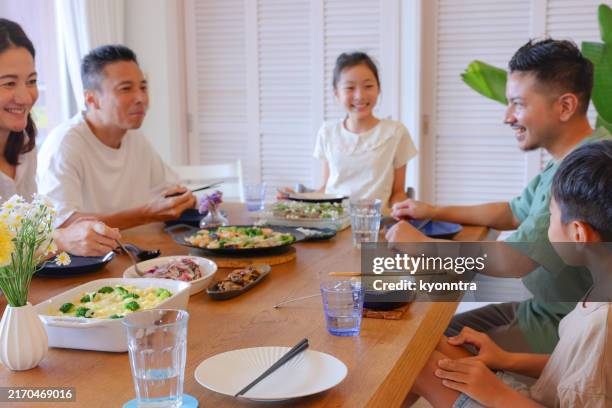 family enjoying a meal together - east asia stock pictures, royalty-free photos & images