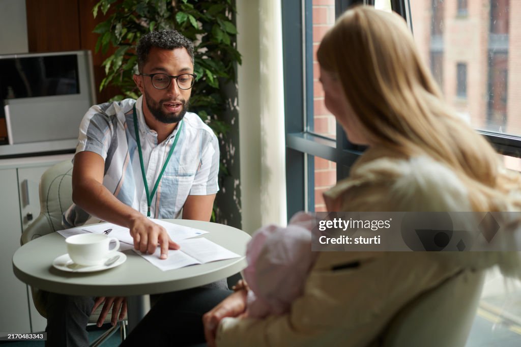 住宅のフォームの助けを得る若いお母さん