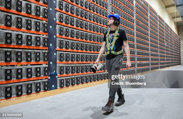 Technician walks near cryptocurrency mining rigs at the Bitfarms Bunker facility in Sherbrooke, Quebec, Canada, on Monday, Sept. 9, 2024. Bitcoin...