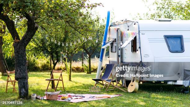 traveling in caravan, camping and exploring new places. picnic diner in front of caravan. - caravan stockfoto's en -beelden