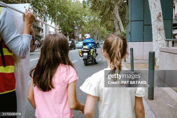 Police motorcyclist in front of two girls from behind during a demonstration by National Education staff against assessments and level groups and for...