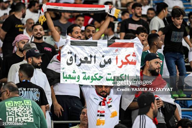 An Iraq supporter holds a message of gratitude to Kuwait before the 2026 FIFA World Cup Asian qualification football match between Kuwait and Iraq at...