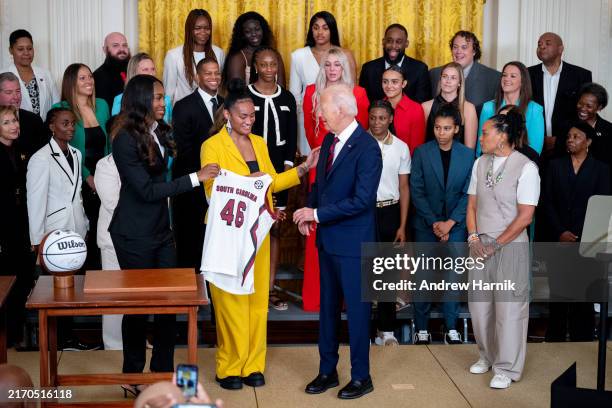 Guards Bree Hall and Te-Hina Paopao presents U.S. President Joe Biden with a team jersey during an event to celebrate the 2023-2024 University of...
