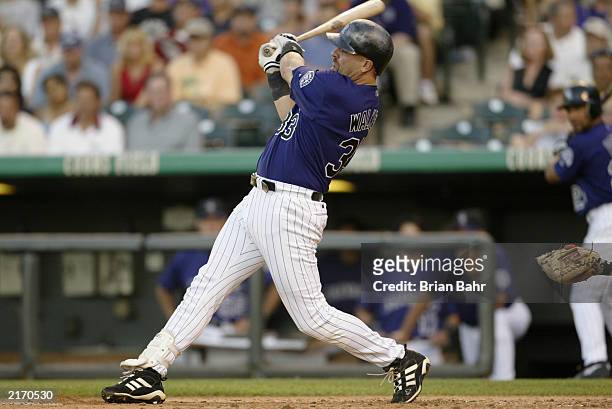 Right fielder Larry Walker of the Colorado Rockies hits a two-run double against the San Francisco Giants during the MLB game at Coors Field on July...