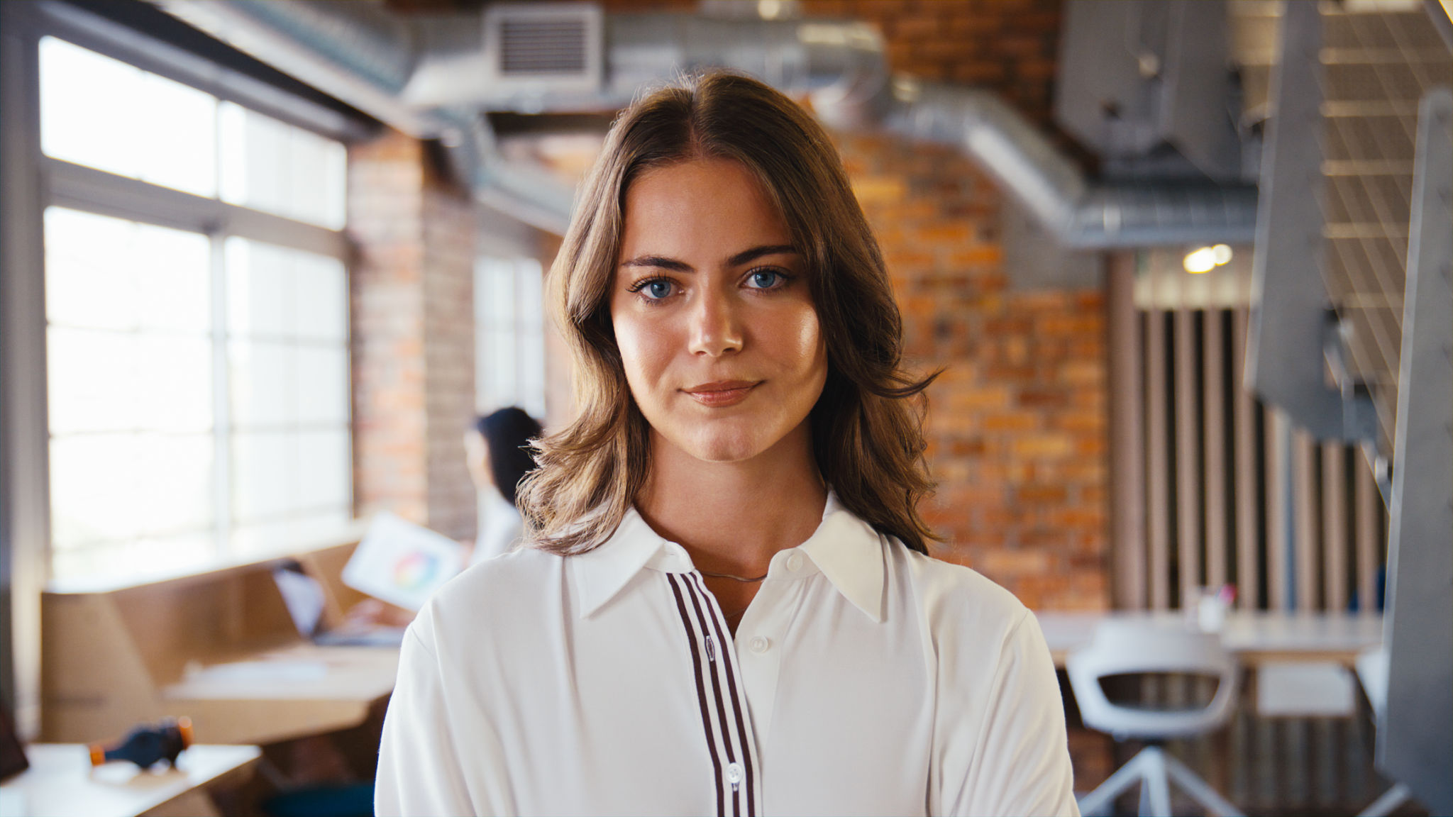 Portrait Of Serious Young Businesswoman Working In Modern Open Plan Office Portrait Of Serious Young Businesswoman Working In Modern Open Plan Office