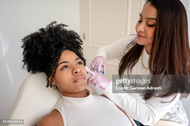 two friends apply botox in a beauty center - beauty treatment stock pictures, royalty-free photos & images