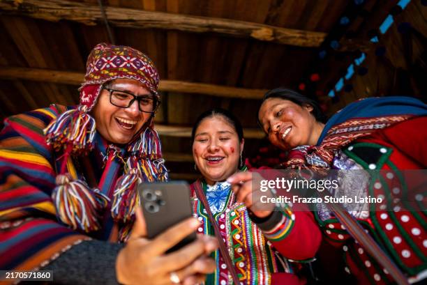 hombre turista mostrando el teléfono móvil chinchero indígena en un mercado, en el distrito de chinchero, perú - cultura tribal americana fotografías e imágenes de stock