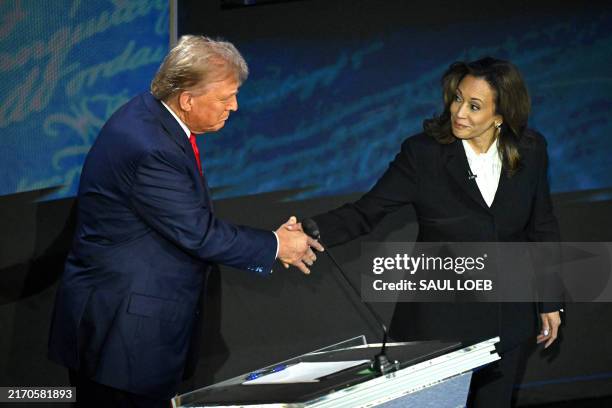 Vice President and Democratic presidential candidate Kamala Harris shakes hands with former US President and Republican presidential candidate Donald...