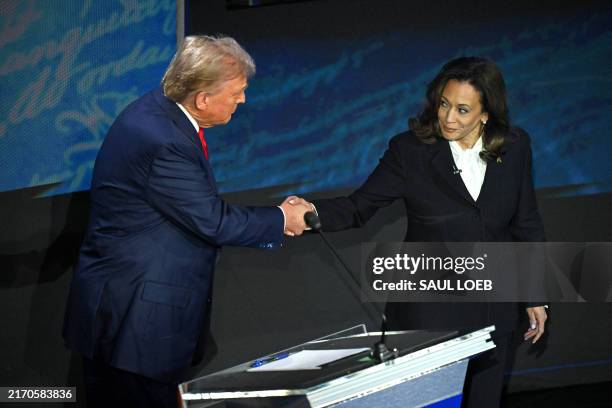 Vice President and Democratic presidential candidate Kamala Harris shakes hands with former US President and Republican presidential candidate Donald...