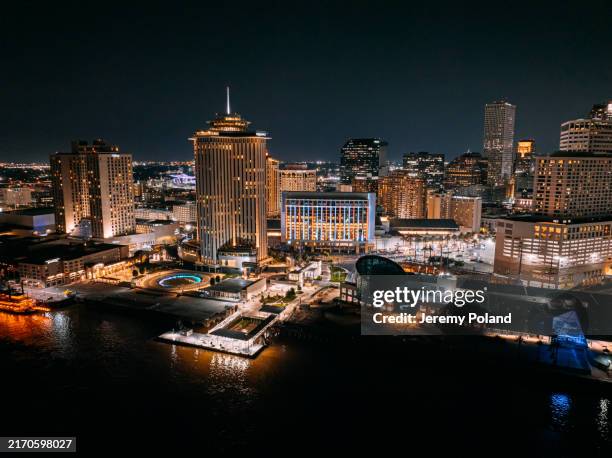 illuminated hotels and the new orleans, louisiana skyline and mississippi river at night - gulf coast states stockfoto's en -beelden