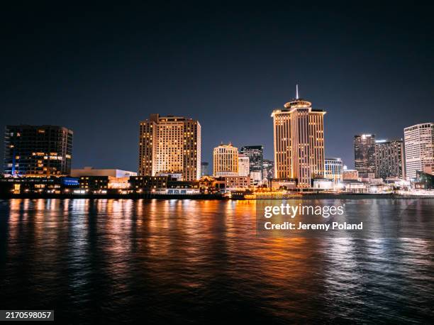 long exposure of riverfront hotels in new orleans, louisiana skyline from the mississippi river at night - bridge architecture up close night stock pictures, royalty-free photos & images