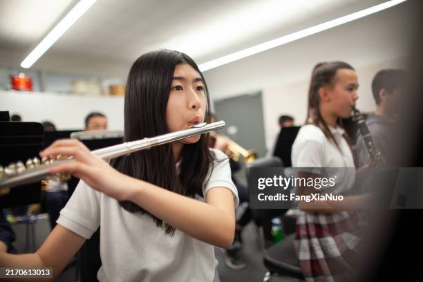 ragazza asiatica coreana studentessa delle scuole medie adolescente che suona il flauto nella pratica della banda musicale - flauto foto e immagini stock