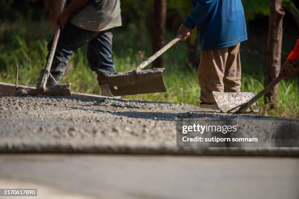 workers are using tools to level concrete in construction work. - paving contractor stock pictures, royalty-free photos & images