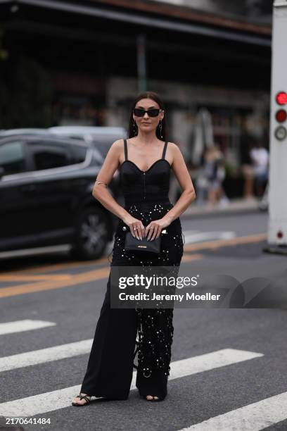Yana Echko seen wearing YSL black sunglasses, silver earrings, Jean Paul Gaultier black corset top, Vince black wide leg pants, MyMokondo black...