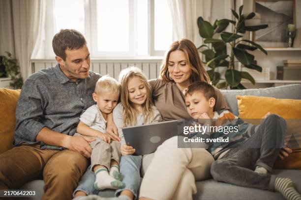 usar la tecnología para conectarse con la familia - familia con tres hijos fotografías e imágenes de stock