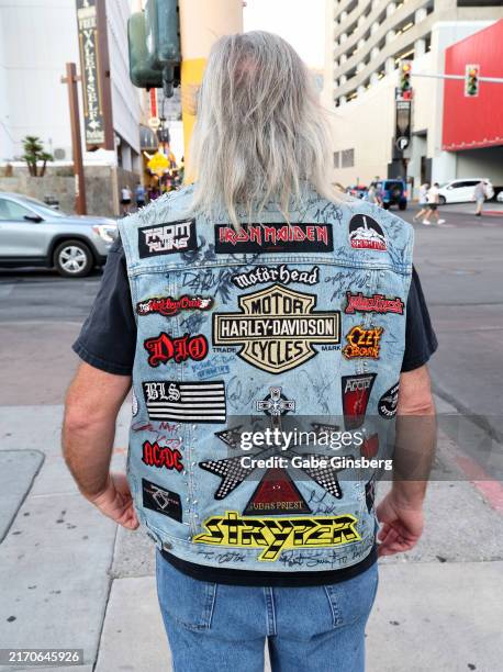An attendee waiting to get into the Vince Neil, Stephen Pearcy and Vixen concert, wears an autographed denim vest with patches from rock bands from...