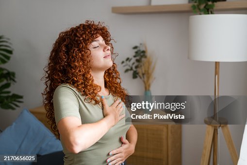 Woman practicing deep breathing exercise at home Woman practicing deep breathing exercise at home