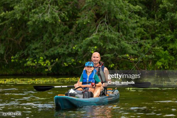 father & son fishing from kayak on lake - kids kayaking stock pictures, royalty-free photos & images