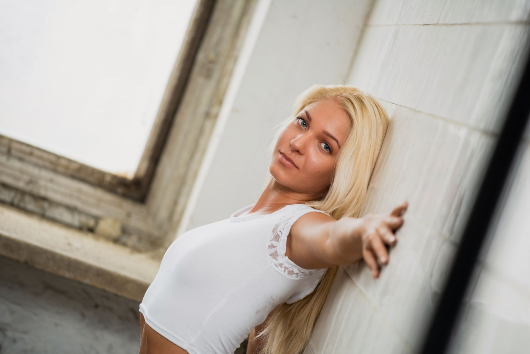 blonde woman leaning against wall in casual outfit blonde woman leaning against wall in casual outfit