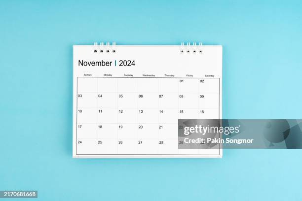 november desk calendar for 2024 year on blue color background. - november stock pictures, royalty-free photos & images