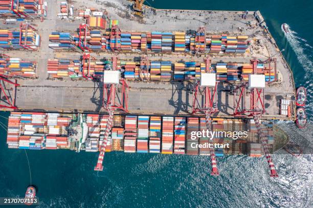 aerial top view container ship in export and import business and logistics. shipping cargo to harbor by crane - remolcador fotografías e imágenes de stock
