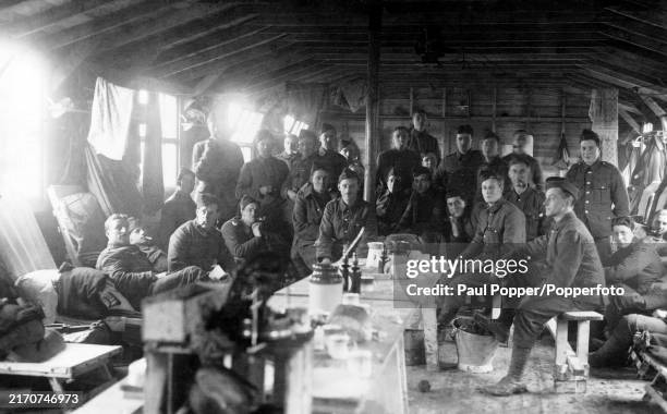Vintage postcard featuring British soldiers of the 16th Middlesex Public Schools Battalion in their billet during World War One, circa 1915.