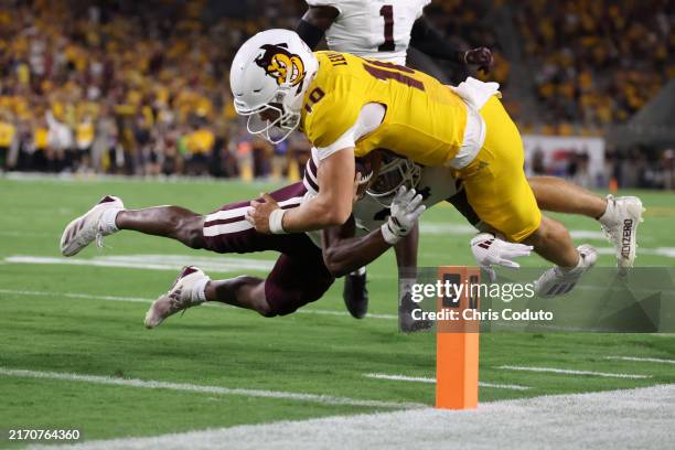 Quarterback Sam Leavitt of the Arizona State Sun Devils dives into the end zone as he's hit by safety Brylan Lanier of the Mississippi State Bulldogs...