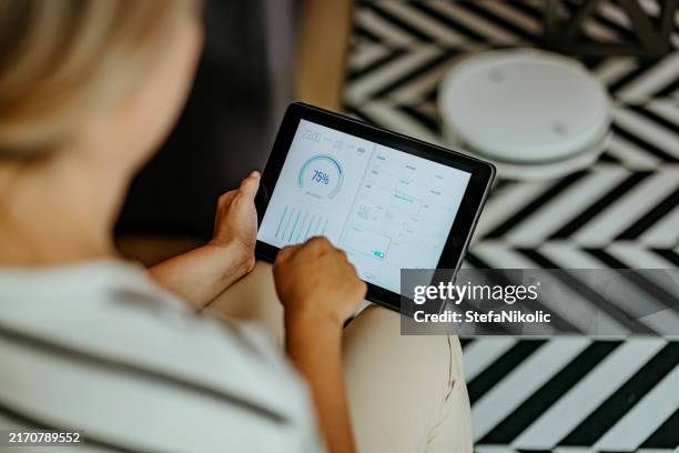 frau mit digitalem tablet - smart meter stock-fotos und bilder