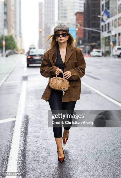 Merve Görgöz wears grey flat cap, brown wild leather jacket, black capri pants, vest, Miu Miu bag outside Simkhai New York Fashion Week on September...