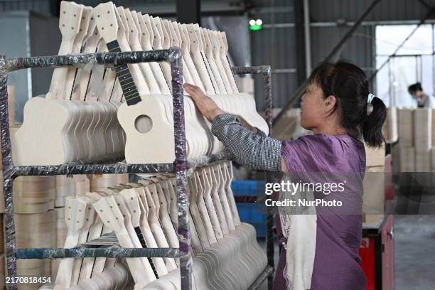 Worker makes a ukulele musical instrument in Suqian, Jiangsu province, China, on September 12, 2024.