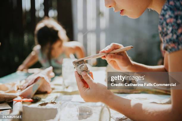 children engaged in creative art and craft activities outdoors during a sunny afternoon in a backyard garden - art class stock pictures, royalty-free photos & images