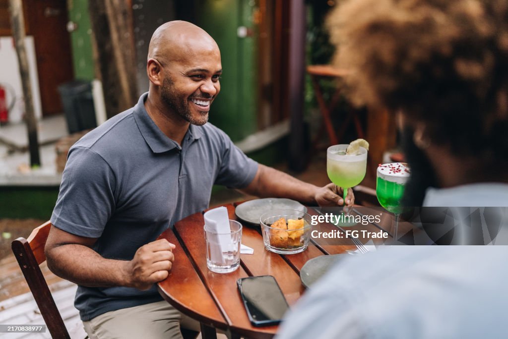 Mature man talking with friend at restaurant