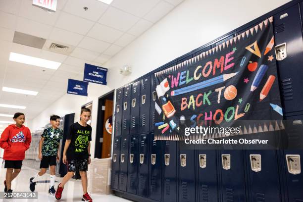 Students walk past a sign that says Welcome Back to School during the first day of school at Lake Norman Charter Middle School in Huntersville, North...