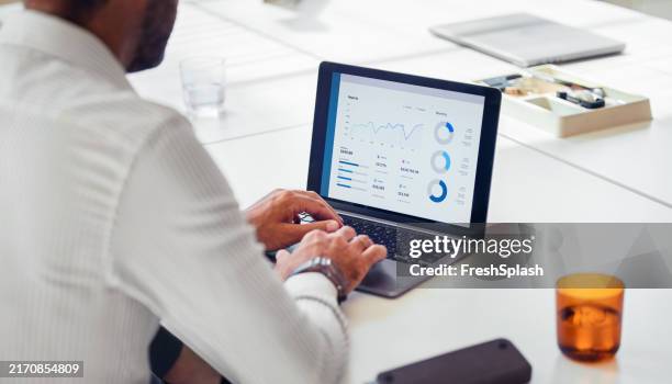 businessman analyzing financial data on laptop in office - man working on computer from behind stock pictures, royalty-free photos & images
