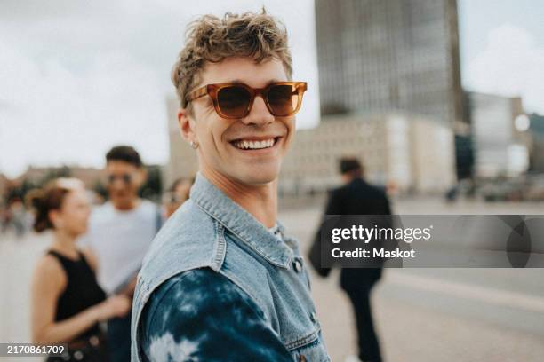 portrait of smiling young man in sunglasses at street - göteborg stad bildbanksfoton och bilder