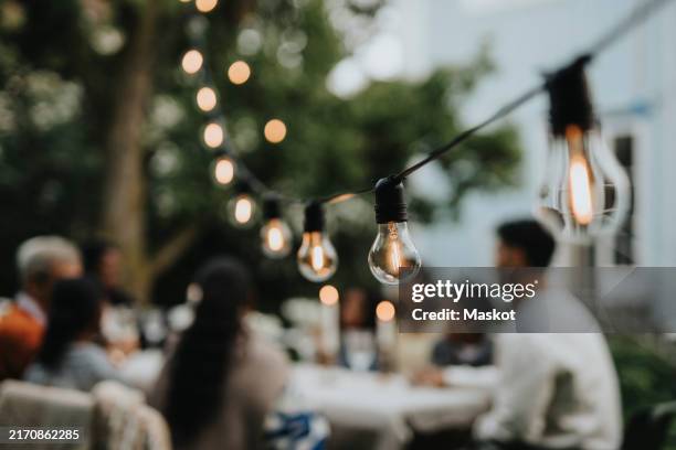 illuminated string lights hanging in garden during party - string light stock pictures, royalty-free photos & images