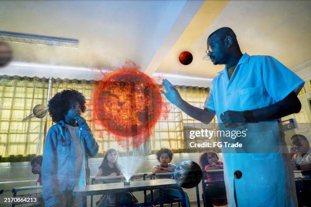 student learning with teacher using a hologram solar system on science class on school - futuristic classroom stock pictures, royalty-free photos & images