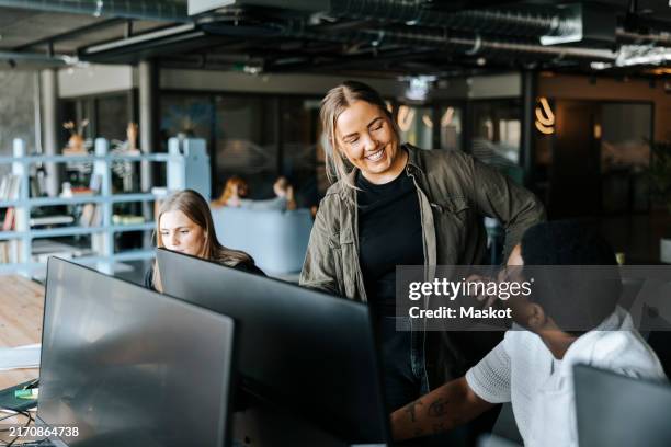 happy male and female entrepreneurs talking in tech startup office - happy person looking at computer screen stock pictures, royalty-free photos & images