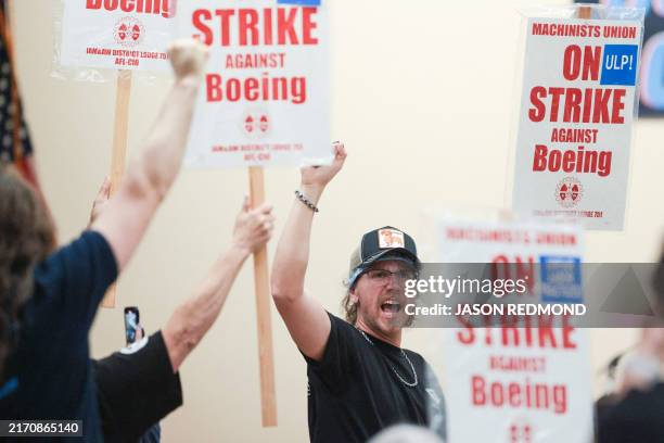 Union members react as Aerospace Machinists District 751 President Jon Holden announces that union members rejected a proposed Boeing contract and...