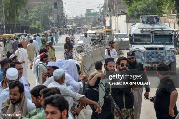 Security personnnel gather as they block a road during a protest against the killing of policemen by the militants in Bannu district, in the...