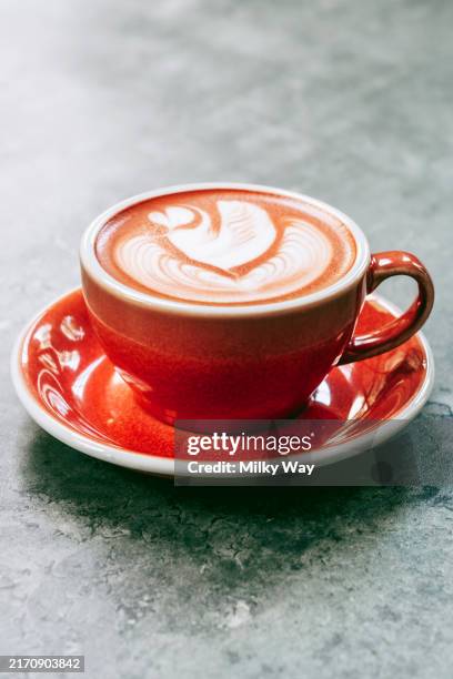 red mug of pink cappuccino with swan latte art on stone surface. beetroot coffee with artful foam design. - mug stock pictures, royalty-free photos & images
