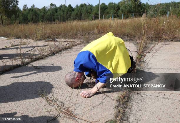 Ukrainian serviceman reacts after being released from Russian captivity at an undisclosed location near the Ukrainian-Belarusian border, on September...