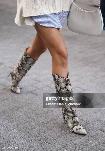 Natalie Zarra is seen wearing a Tommy Hilfiger sweater, Tommy Hilfiger white and blue striped shirt, snakeskin boots, white Tommy Hilfiger bag and...