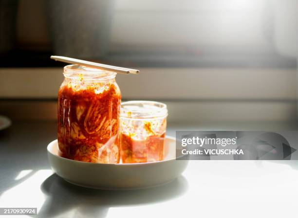 kimchi in jars on the kitchen table with chopsticks - jar stock pictures, royalty-free photos & images