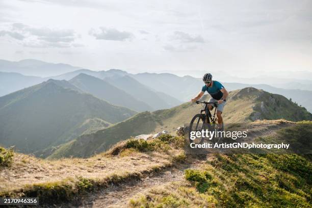 mountain biker riding in mountain. - mountain ridge stock pictures, royalty-free photos & images